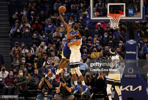 Andrew Wiggins of the Golden State Warriors dunks the ball over Karl-Anthony Towns of the Minnesota Timberwolves in the first half at Chase Center on...