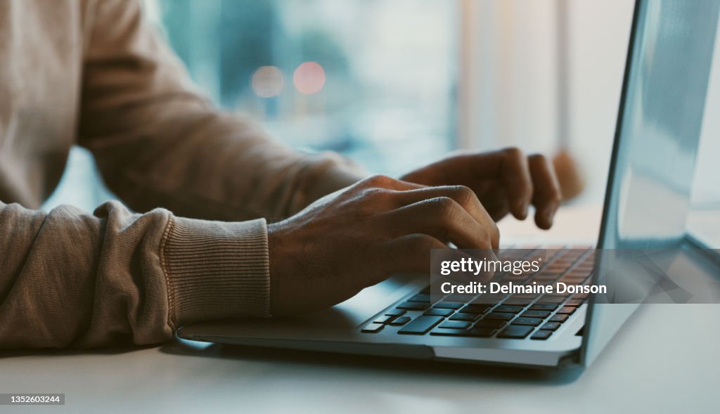 Shot of an unrecognizable businessman working on his laptop in the office