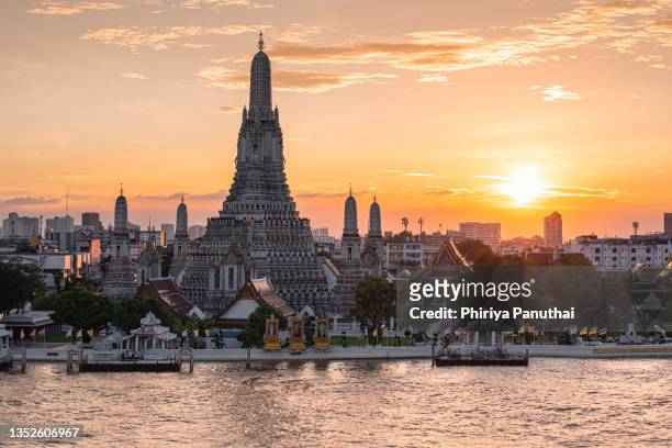 wat arun ratchawararam temple at sunset in bangkok thailand. wat arun is a buddhist temple in bangkok yai district of bangkok, thailand, wat arun is among the best known of thailand's landmarks - bangkok river stock pictures, royalty-free photos & images
