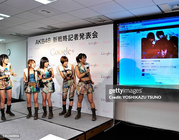 Japanese all-girl pop group AKB48 members Rino Sashihara, Minami Takahashi, Atsuko Maeda, Mariko Shinoda and Aki Takajo check their uploaded...