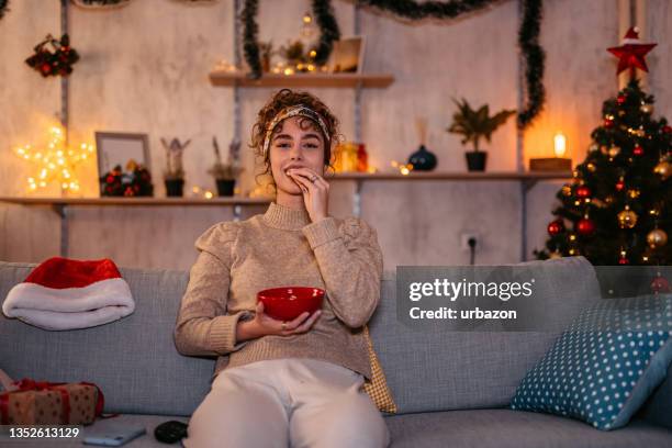 frau schaut film und isst snacks zu weihnachten - eating alone stock-fotos und bilder