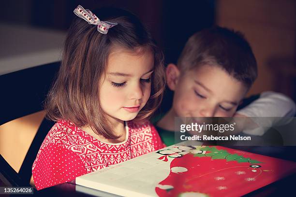 brother and sister looking at advent calendar - avent photos et images de collection