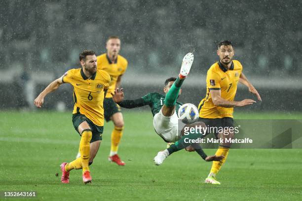 Abdulelah Alamri of Saudi Arabia attempts to clear the ball under pressure from Matthew Leckie of Australia during the FIFA World Cup AFC Asian...