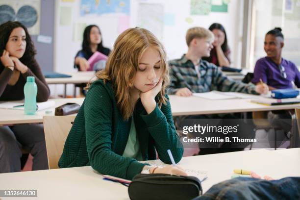 student concentrating while working in classroom - bambino di età scolare foto e immagini stock