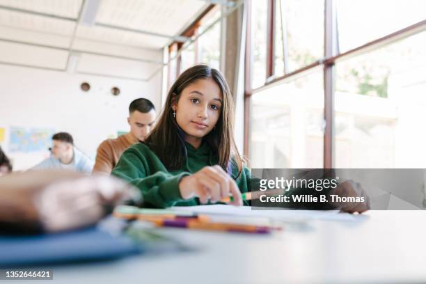 student sitting at desk in class by large window - straight hair stock pictures, royalty-free photos & images