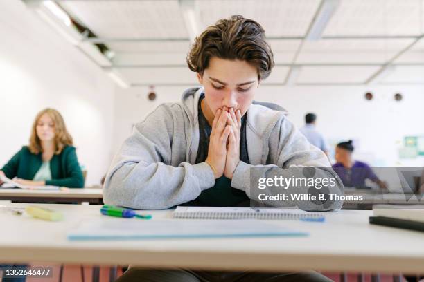 worried student looking at test - weiterbildung stock-fotos und bilder