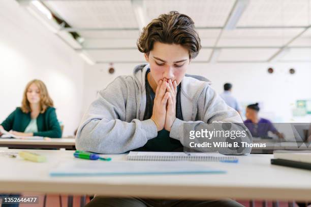 worried student looking at test - students studying imagens e fotografias de stock