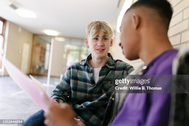 two high school students talking about homework before next class - dialog und bildung stock-fotos und bilder