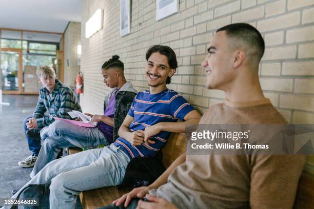 friends hanging out between classes in high school - teenager männlich stock-fotos und bilder