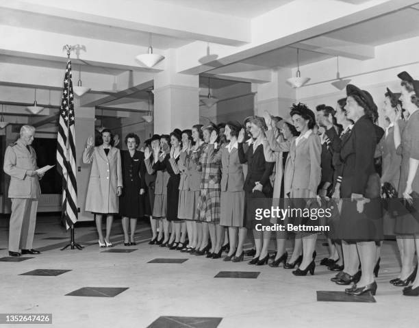 Captain Kenneth Castleman administers the oath of allegiance to the first intake of trainee officer candidates of the United States Naval Reserve ,...