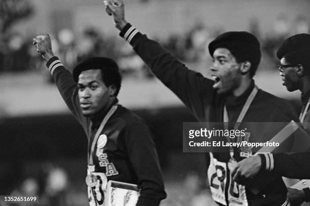 American athletes, from left, Lee Evans and Larry James of the United States on the podium after the US team finished in first place to win the gold...