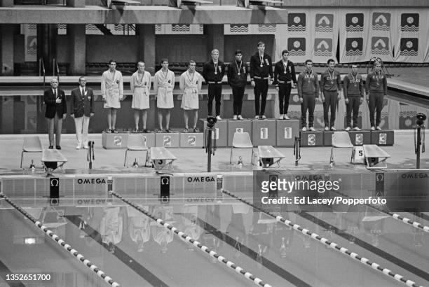 The United States team of, from left, Don Schollander, Mark Spitz, Stephen Rerych and John Nelson stand in centre on the podium after the USA team...