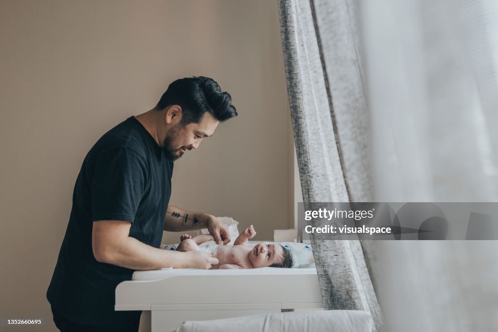 Father changing his baby's diaper