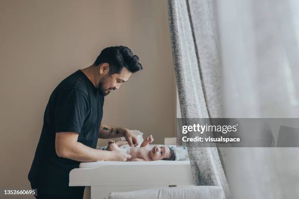 father changing his baby's diaper - changing nappy stock pictures, royalty-free photos & images