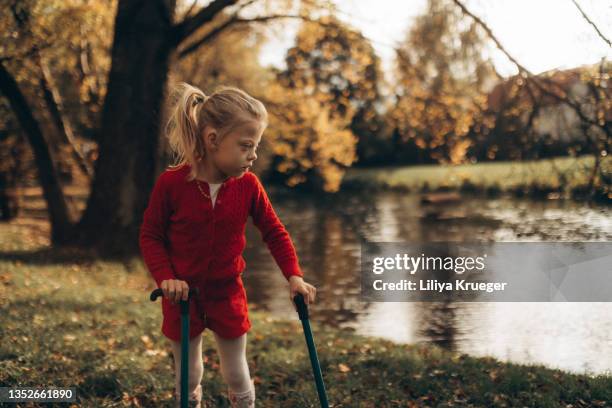 disabled girl walks along the river. - cerebal palsy stockfoto's en -beelden