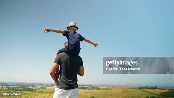 young son on fathers shoulders in countryside - family city break stock pictures, royalty-free photos & images