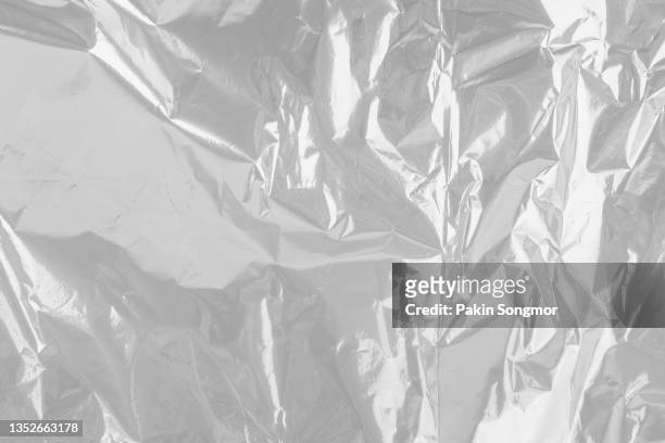 close up silver plastic foil background, abstract background of silver color from paper. - foil foto e immagini stock