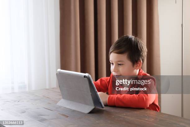 4-5 years old child using digital tablet at home - 4 5 years stock pictures, royalty-free photos & images