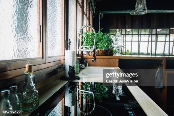 cozy interior of modern open kitchen, with kitchen accessories and cooking utensils. sunlight coming through window - hob stock pictures, royalty-free photos & images