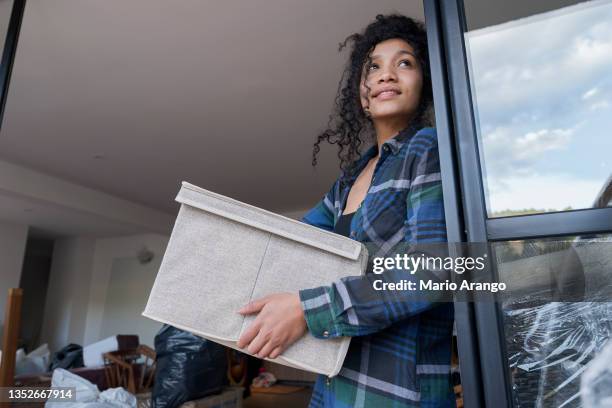 young curly brunette woman carries her toiletry bag while enjoying the joy of leaving home - house rental bildbanksfoton och bilder