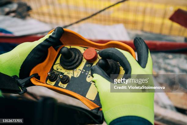 engineer holding and working with remote control for operating crane. - crane stock pictures, royalty-free photos & images