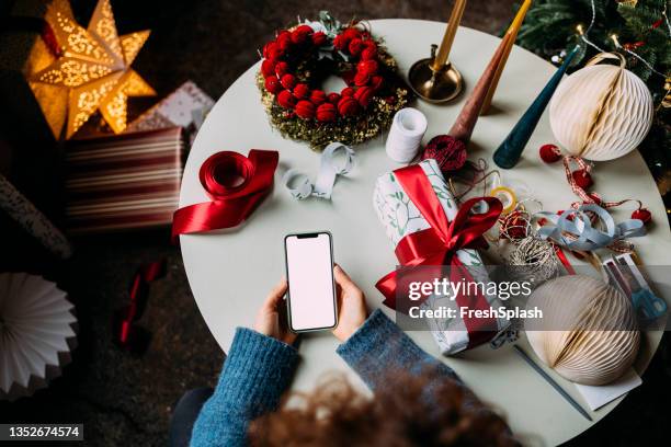 woman using a mobile phone in a christmas setting (copy space) - shopping online blue stock pictures, royalty-free photos & images