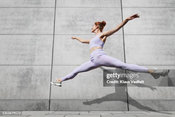 elegant female ballet performer doing splits on sunny day - urban ballet imagens e fotografias de stock