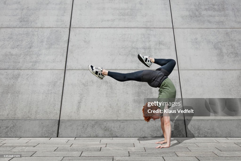 Young male dancer balancing on footpath