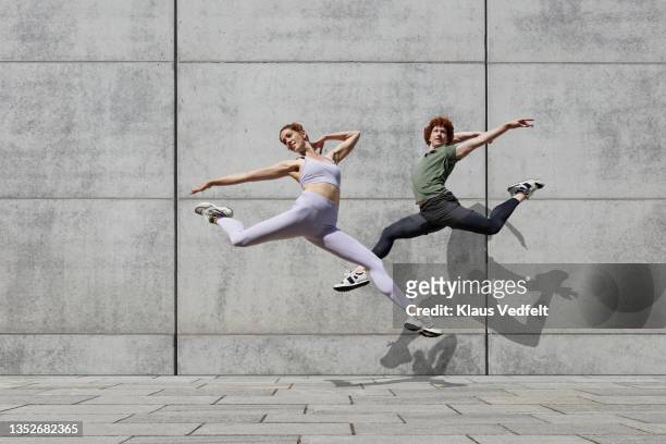 graceful ballet dancers jumping together - nur erwachsene stock-fotos und bilder