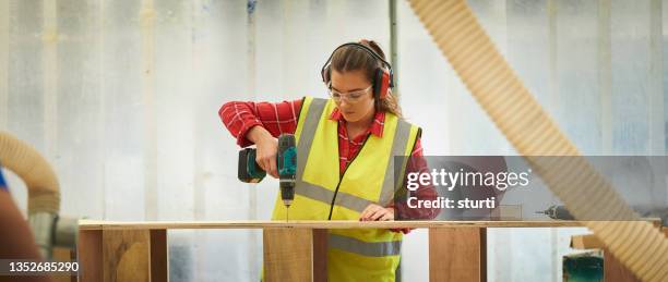 aprendiz de carpintero en el taller - orejeras fotografías e imágenes de stock