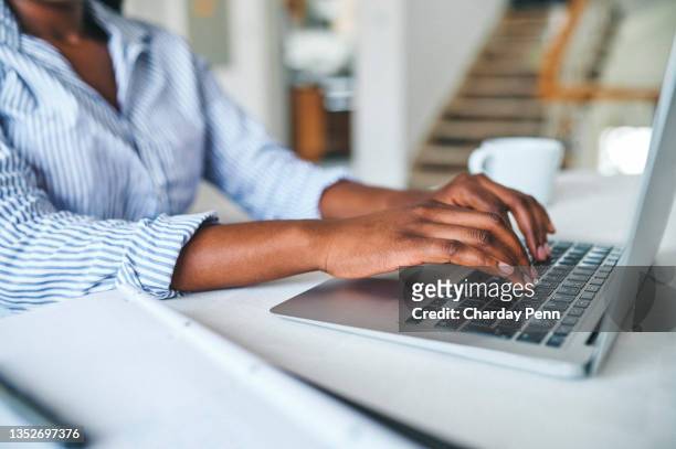 closeup shot of an unrecognisable woman using a laptop at home - human hand stockfoto's en -beelden