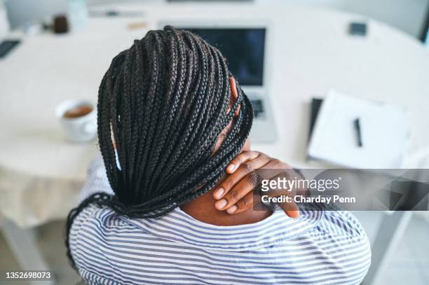 vue arrière d’une jeune femme souffrant de douleurs au cou alors qu’elle travaillait à la maison - back injury photos et images de collection