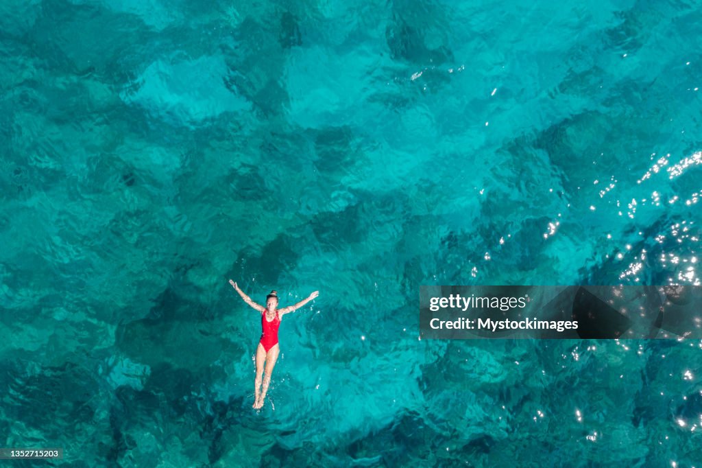Mujer flotando mar turquesa