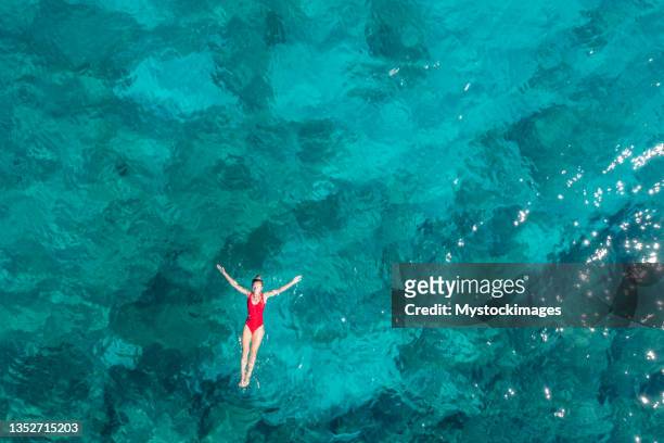 femme flottant mer turquoise - mer photos et images de collection