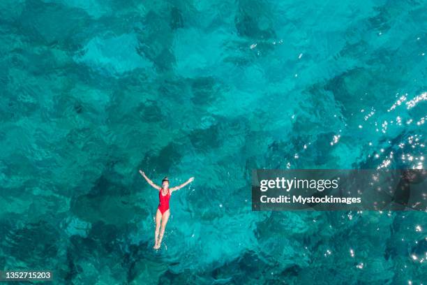 woman floating turquoise sea - turquoise colored nature stock pictures, royalty-free photos & images