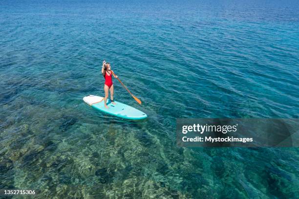 aerial view of woman on a stand up paddle - oar stock pictures, royalty-free photos & images