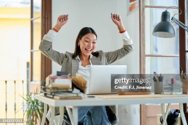 woman with triumph gesture in office - aansporing stockfoto's en -beelden