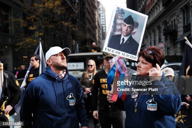 Families of soldiers who died by suicide hold signs in support of their loved ones during the Veterans Day Parade on November 11, 2021 in New York...