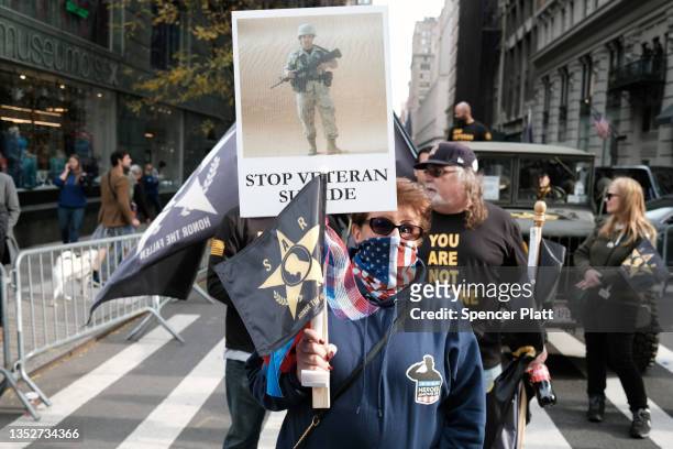 Families of soldiers who died by suicide hold signs in support of their loved ones during the Veterans Day Parade on November 11, 2021 in New York...