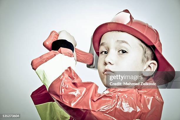 little firefighter in halloween costume - boy fireman costume stock pictures, royalty-free photos & images
