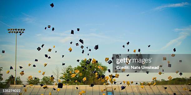 graduates tossing mortar boards in air - mortarboard stock pictures, royalty-free photos & images