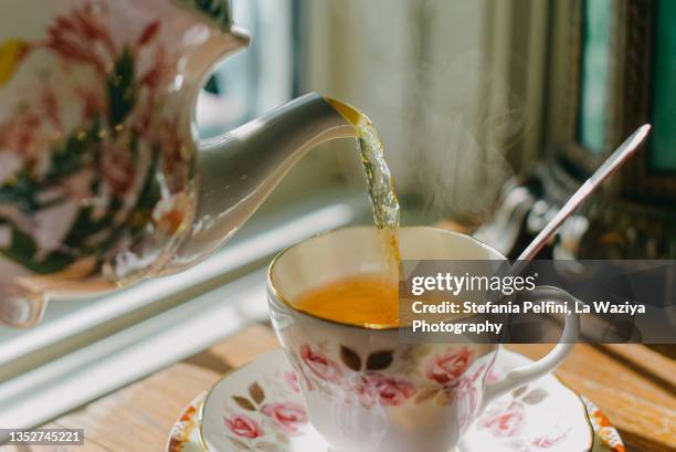 teapot pouring tea in teacup - 2021 premios de la imagens e fotografias de stock