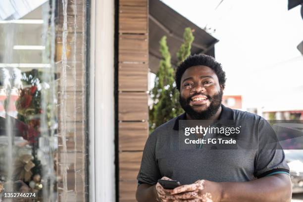 portrait of a man using mobile phone at street - chubby man shopping stock pictures, royalty-free photos & images