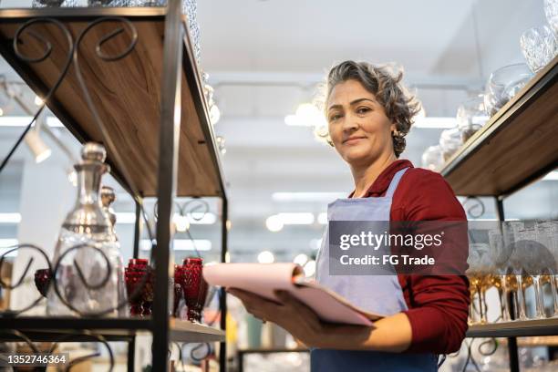 portrait of a saleswoman checking out products at a furniture store - portrait department store stockfoto's en -beelden