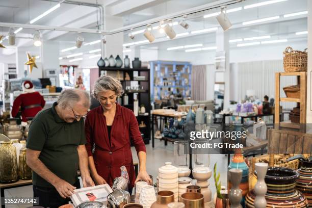 couple choosing products at a decoration store - home decor store stock pictures, royalty-free photos & images