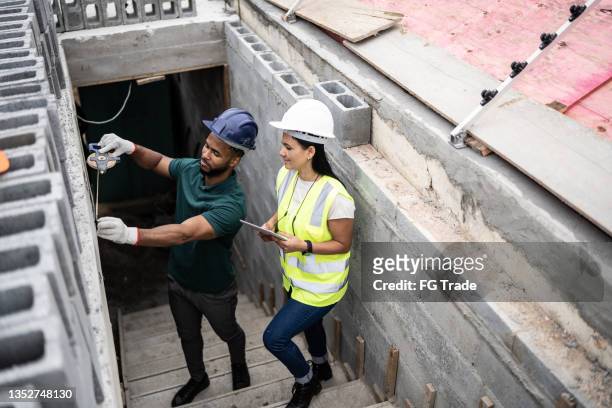 engineer supervising bricklayer working - female bricklayer stock pictures, royalty-free photos & images
