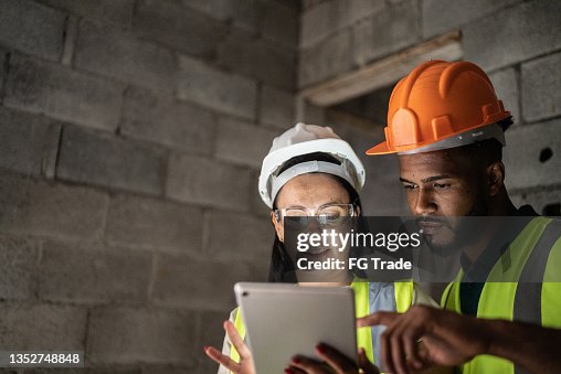 Construction site workers using digital tablet having a meeting Construction site workers using digital tablet having a meeting
