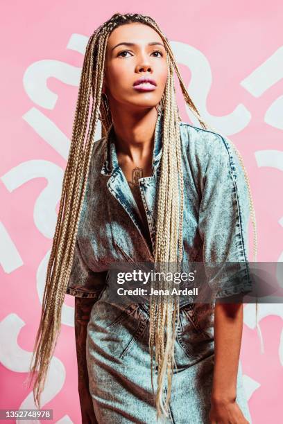 fashionable woman with long braids wearing acid wash denim dress late 1980s style, early 1990s style - 80's hair stockfoto's en -beelden