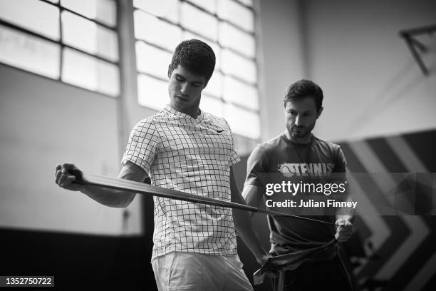Carlos Alcaraz of Spain stretches in the gym with physio and rehab specialist Juanjo Moreno during Day Three of the Next Gen ATP Finals at Palalido...