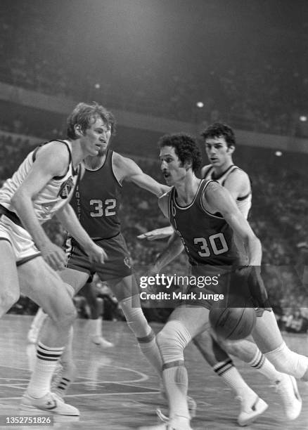 Portland Trail Blazers forward Bob Gross attempts to dribble the ball past center Dan Issel during an NBA playoff game against the Denver Nuggets at...